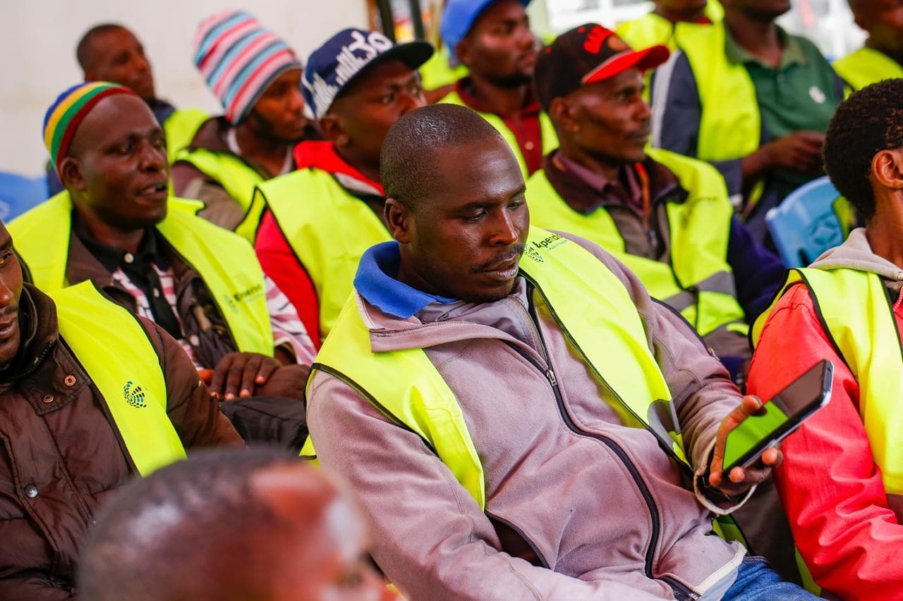 Boda boda riders in Expendo vests listening at event